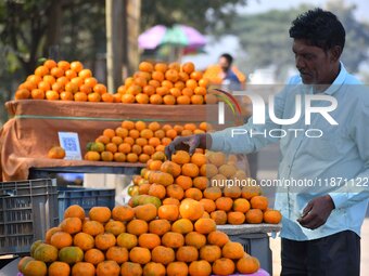 A vendor arranges oranges at his roadside shop for sale near Sonapur in Kamrup District of Assam, India, on December 15, 2024. (