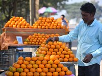 A vendor arranges oranges at his roadside shop for sale near Sonapur in Kamrup District of Assam, India, on December 15, 2024. (