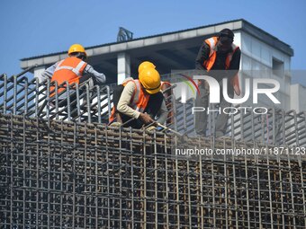 Workers work on the construction of a bridge in Guwahati, India, on December 15, 2024. (