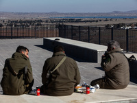 Israeli soldiers and Israeli civilians visit a lookout point next to the boundary fence delineating the UN-patrolled buffer zone between Isr...