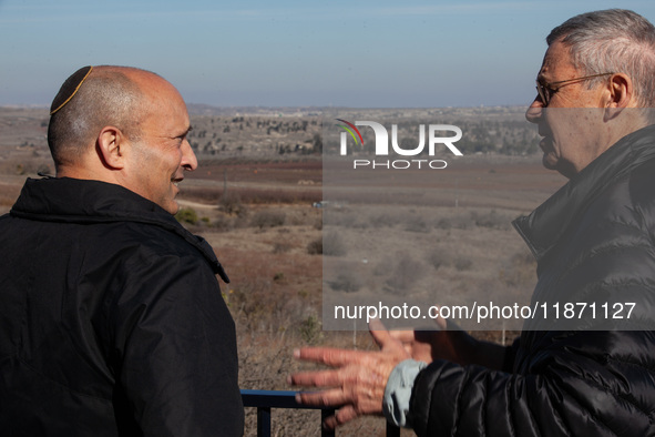 Former Israeli prime minister Naftali Bennett (left) and Israeli civilians visit a lookout point next to the boundary fence delineating the...