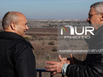 Former Israeli prime minister Naftali Bennett (left) and Israeli civilians visit a lookout point next to the boundary fence delineating the...