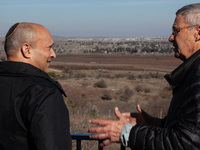 Former Israeli prime minister Naftali Bennett (left) and Israeli civilians visit a lookout point next to the boundary fence delineating the...