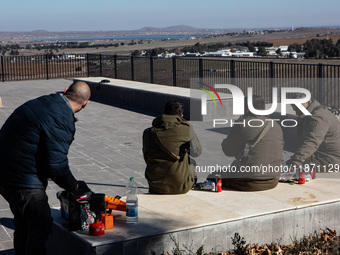 Israeli soldiers and civilians visit a lookout point next to the boundary fence delineating the UN-patrolled buffer zone between Israel and...