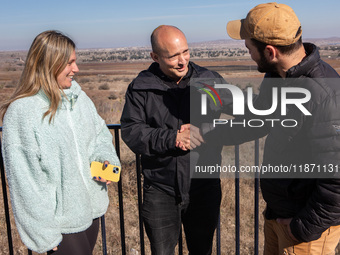 Former Israeli prime minister Naftali Bennett (center) and Israeli civilians visit a lookout point next to the boundary fence delineating th...