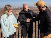 Former Israeli prime minister Naftali Bennett (center) and Israeli civilians visit a lookout point next to the boundary fence delineating th...