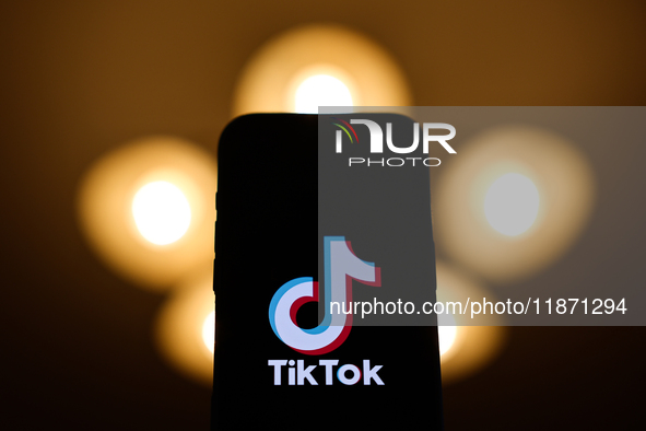 TikTok logo displayed on a phone screen is seen in this illustration photo taken in Poland on December 15, 2024. 