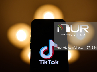 TikTok logo displayed on a phone screen is seen in this illustration photo taken in Poland on December 15, 2024. (