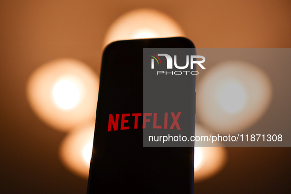 Netflix logo displayed on a phone screen is seen in this illustration photo taken in Poland on December 15, 2024. 