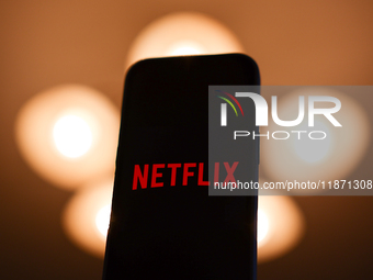 Netflix logo displayed on a phone screen is seen in this illustration photo taken in Poland on December 15, 2024. (