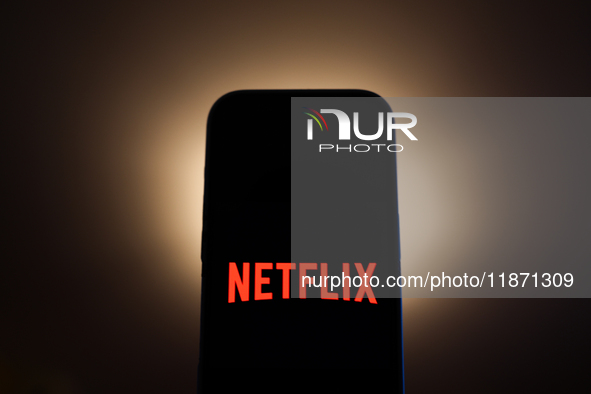 Netflix logo displayed on a phone screen is seen in this illustration photo taken in Poland on December 15, 2024. 