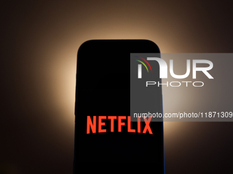 Netflix logo displayed on a phone screen is seen in this illustration photo taken in Poland on December 15, 2024. (