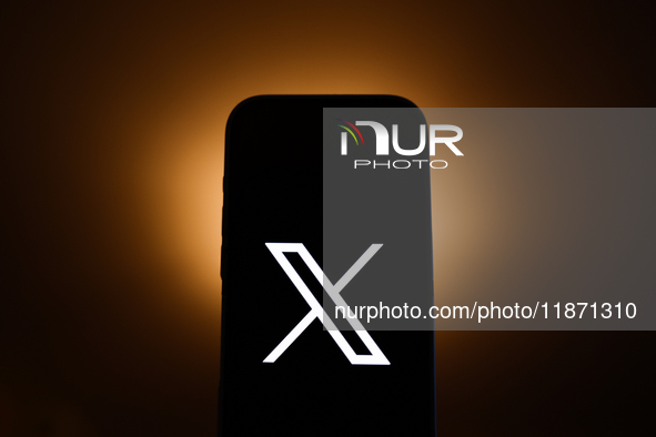 X logo displayed on a phone screen is seen in this illustration photo taken in Poland on December 15, 2024. 