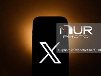 X logo displayed on a phone screen is seen in this illustration photo taken in Poland on December 15, 2024. (