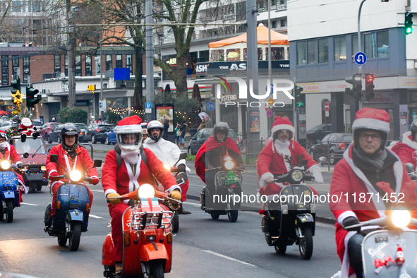 Dozen members of the Vespa club dress as Santa Claus and ride around downtown Cologne, Germany, on December 15, 2024. 