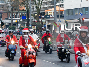 Dozen members of the Vespa club dress as Santa Claus and ride around downtown Cologne, Germany, on December 15, 2024. (