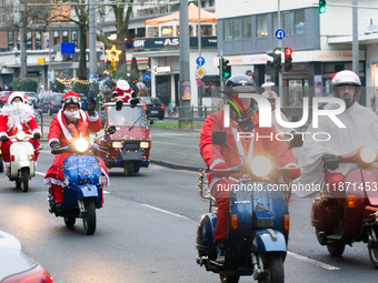 Dozen members of the Vespa club dress as Santa Claus and ride around downtown Cologne, Germany, on December 15, 2024. (