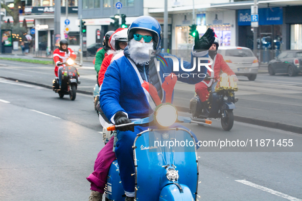 Dozen members of the Vespa club dress as Santa Claus and ride around downtown Cologne, Germany, on December 15, 2024. 