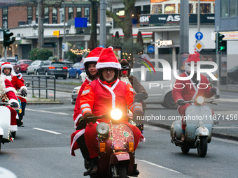 Dozen members of the Vespa club dress as Santa Claus and ride around downtown Cologne, Germany, on December 15, 2024. (