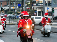 Dozen members of the Vespa club dress as Santa Claus and ride around downtown Cologne, Germany, on December 15, 2024. (