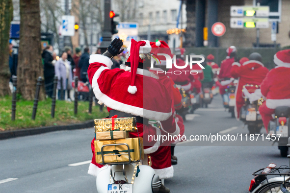 Dozen members of the Vespa club dress as Santa Claus and ride around downtown Cologne, Germany, on December 15, 2024. 