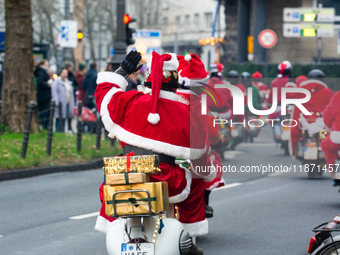 Dozen members of the Vespa club dress as Santa Claus and ride around downtown Cologne, Germany, on December 15, 2024. (