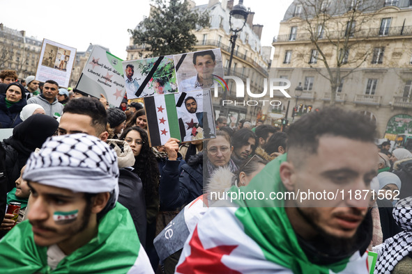 A demonstrator holds flags and banners during a demonstration in support of the Syrian people and to celebrate the fall of Syrian President...