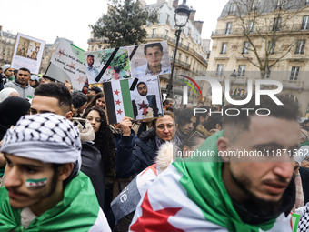 A demonstrator holds flags and banners during a demonstration in support of the Syrian people and to celebrate the fall of Syrian President...