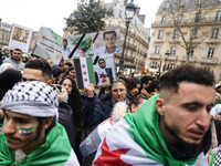 A demonstrator holds flags and banners during a demonstration in support of the Syrian people and to celebrate the fall of Syrian President...