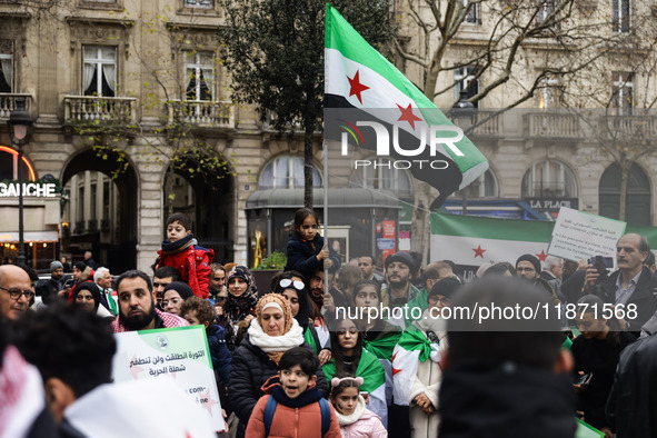 A demonstrator holds flags and banners during a demonstration in support of the Syrian people and to celebrate the fall of Syrian President...