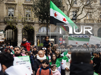 A demonstrator holds flags and banners during a demonstration in support of the Syrian people and to celebrate the fall of Syrian President...