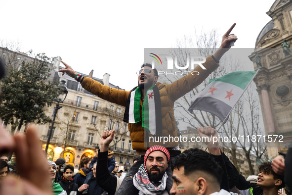 A demonstrator holds flags and banners during a demonstration in support of the Syrian people and to celebrate the fall of Syrian President...