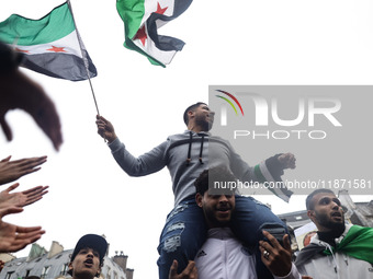 A demonstrator holds flags and banners during a demonstration in support of the Syrian people and to celebrate the fall of Syrian President...