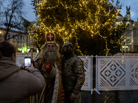 A Ukrainian soldier takes a photo with a man dressed as St. Nicholas near the Main Christmas tree in Lviv, Ukraine, on December 15, 2024. (