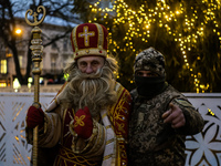 A Ukrainian soldier takes a photo with a man dressed as St. Nicholas near the Main Christmas tree in Lviv, Ukraine, on December 15, 2024. (