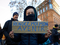 A child holds a placard reading 'Give me back my future'. Between 100 and 1500 people gather in Toulouse, France, on December 15, 2024, to p...