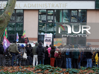 People stand in front of the Administrative Court while others speak. Between 100 and 1500 people gather in Toulouse, France, on December 15...