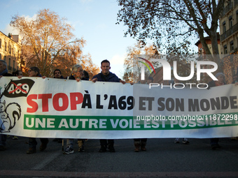 The banner reads 'Stop to the A69 and its world, another way is possible'. Between 1,000 and 1,500 people gather in Toulouse, France, on Dec...