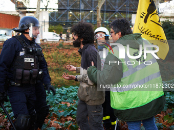 A protester argues with a riot policeman to recover his bag. Between 1,000 and 1,500 people gather in Toulouse, France, on December 15, 2024...