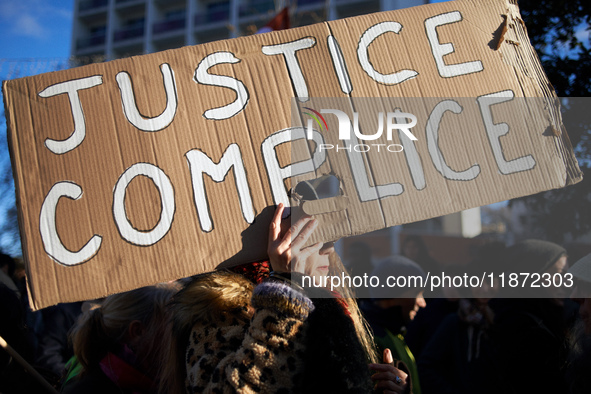 A woman holds a placard reading 'Justice accomplice'. Between 100 and 1500 people gather in Toulouse, France, on December 15, 2024, against...