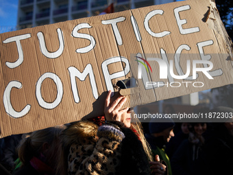 A woman holds a placard reading 'Justice accomplice'. Between 100 and 1500 people gather in Toulouse, France, on December 15, 2024, against...