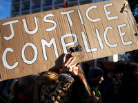 A woman holds a placard reading 'Justice accomplice'. Between 100 and 1500 people gather in Toulouse, France, on December 15, 2024, against...