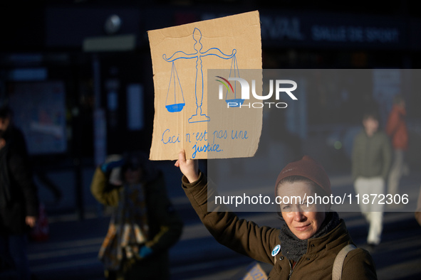 A protester holds a placard depicting the balance of justice and reading 'this is not justice'. Between 100 and 1500 people gather in Toulou...