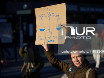 A protester holds a placard depicting the balance of justice and reading 'this is not justice'. Between 100 and 1500 people gather in Toulou...