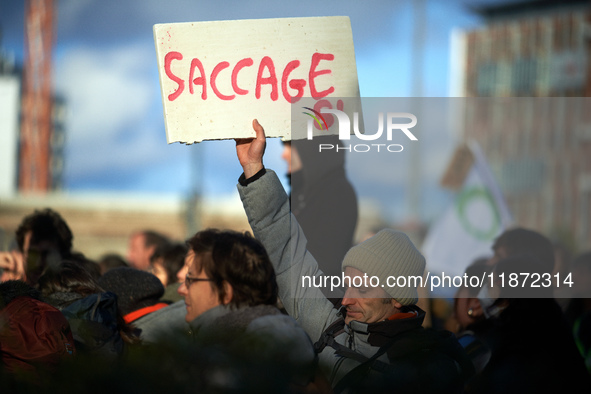 A man holds a placard reading 'Ransacking'. Between 1,000 and 1,500 people gather in Toulouse, France, on December 15, 2024, against a non-a...