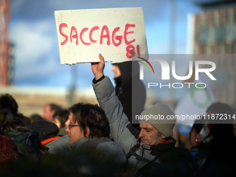 A man holds a placard reading 'Ransacking'. Between 1,000 and 1,500 people gather in Toulouse, France, on December 15, 2024, against a non-a...