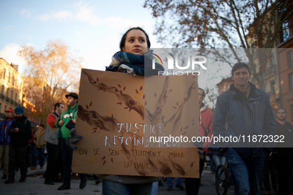 A young woman holds a placard reading 'Justice, come with us'. Between 1,000 and 1,500 people gather in Toulouse, France, on December 15, 20...