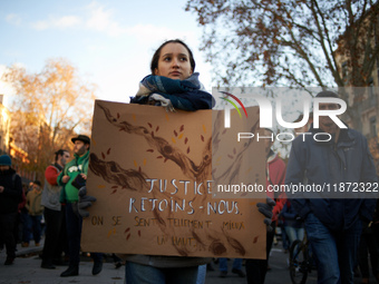 A young woman holds a placard reading 'Justice, come with us'. Between 1,000 and 1,500 people gather in Toulouse, France, on December 15, 20...