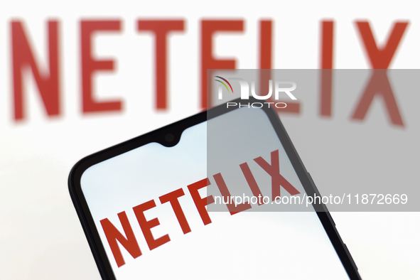 The Netflix logo appears on the screen of a smartphone and in the background on the computer screen in Reno, United States, on December 15,...