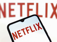 The Netflix logo appears on the screen of a smartphone and in the background on the computer screen in Reno, United States, on December 15,...